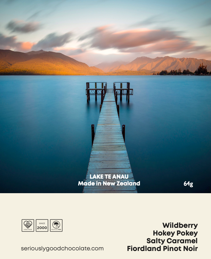 A box of chocolate with a scenic image of a lake and a pier at sunset on the packaging, labeled 'Lake Te Anau'.
