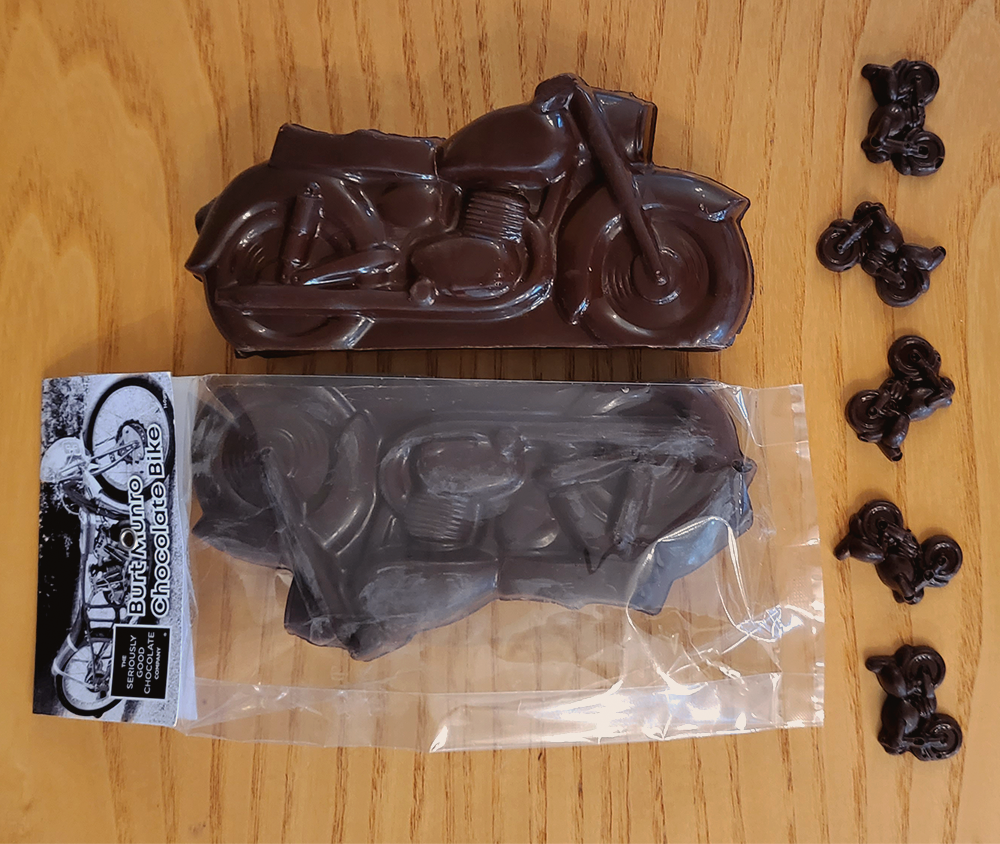2 Large Dark Chocolate Motorbikes, one packaged, from the Seriously Good Chocolate Burt Munro Collection with tiny chocolate bikes decorating beside