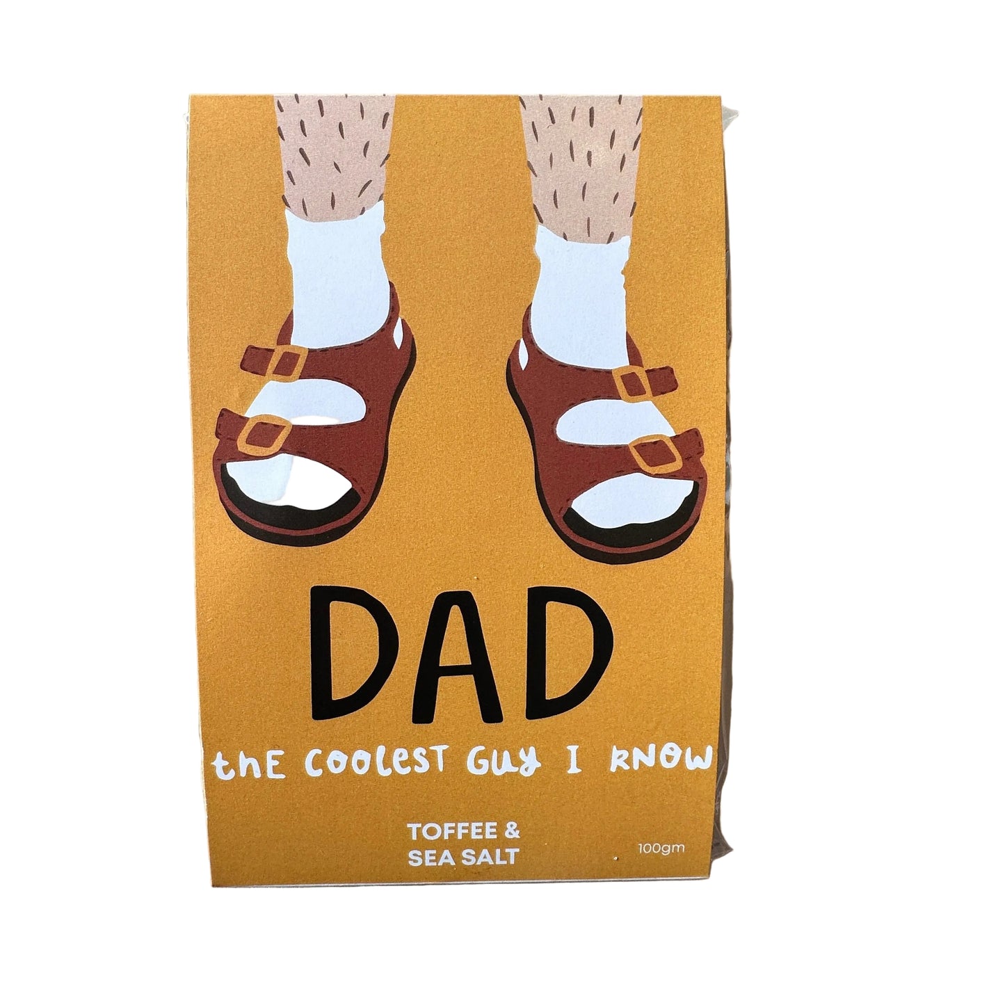 A packaged chocolate block with an illustration of a pair of hands wearing sandals on the front, labeled 'DAD - THE COOLEST GUY I KNOW - TOFFEE & SEA SALT'.
