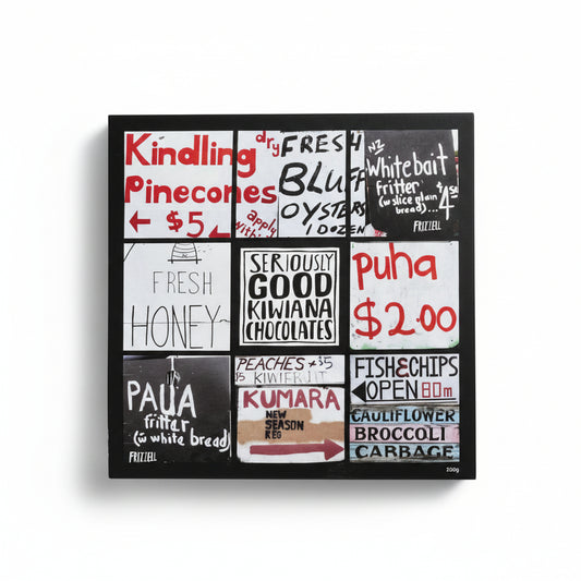 A box of chocolate candies with a colorful, artistically designed packaging featuring text and branding, with some chocolates visible inside the open box.