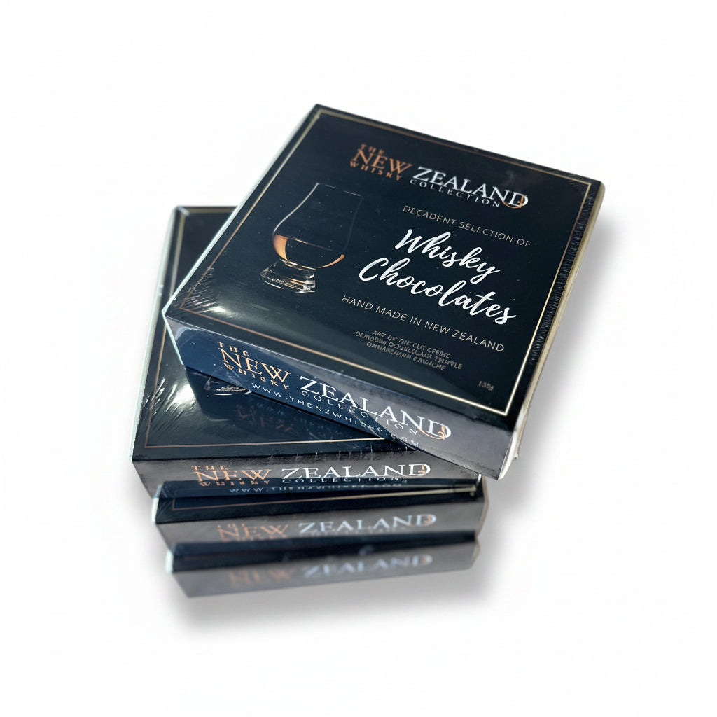 A stack of black boxes labeled 'New Zealand' containing 'Whisky Chocolates', indicating they are hand made in New Zealand.