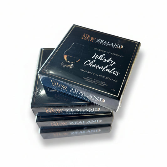 A stack of black boxes labeled 'New Zealand' containing 'Whisky Chocolates', indicating they are hand made in New Zealand.