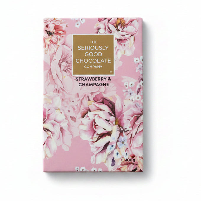 Chocolate bar packaging with floral design surrounded by flowers on a wooden surface
