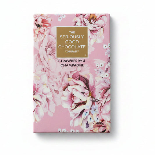 Chocolate bar packaging with floral design surrounded by flowers on a wooden surface