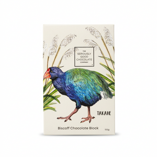 A 100g box of The Seriously Good Chocolate Company's 'Takahe' Biscoff Chocolate Block. The packaging features a cream-colored background with an illustration of a blue and green takahe bird standing among white reeds.