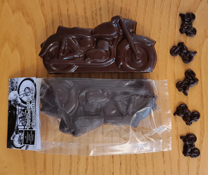2 Large Dark Chocolate Motorbikes, one packaged,  from the Seriously Good Chocolate Burt Munro Collection with tiny chocolate bikes decorating beside