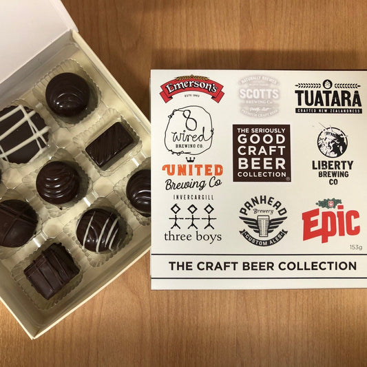 An open box of chocolate candies with various designs, labeled as 'The Craft Beer Collection' with branding from different breweries.