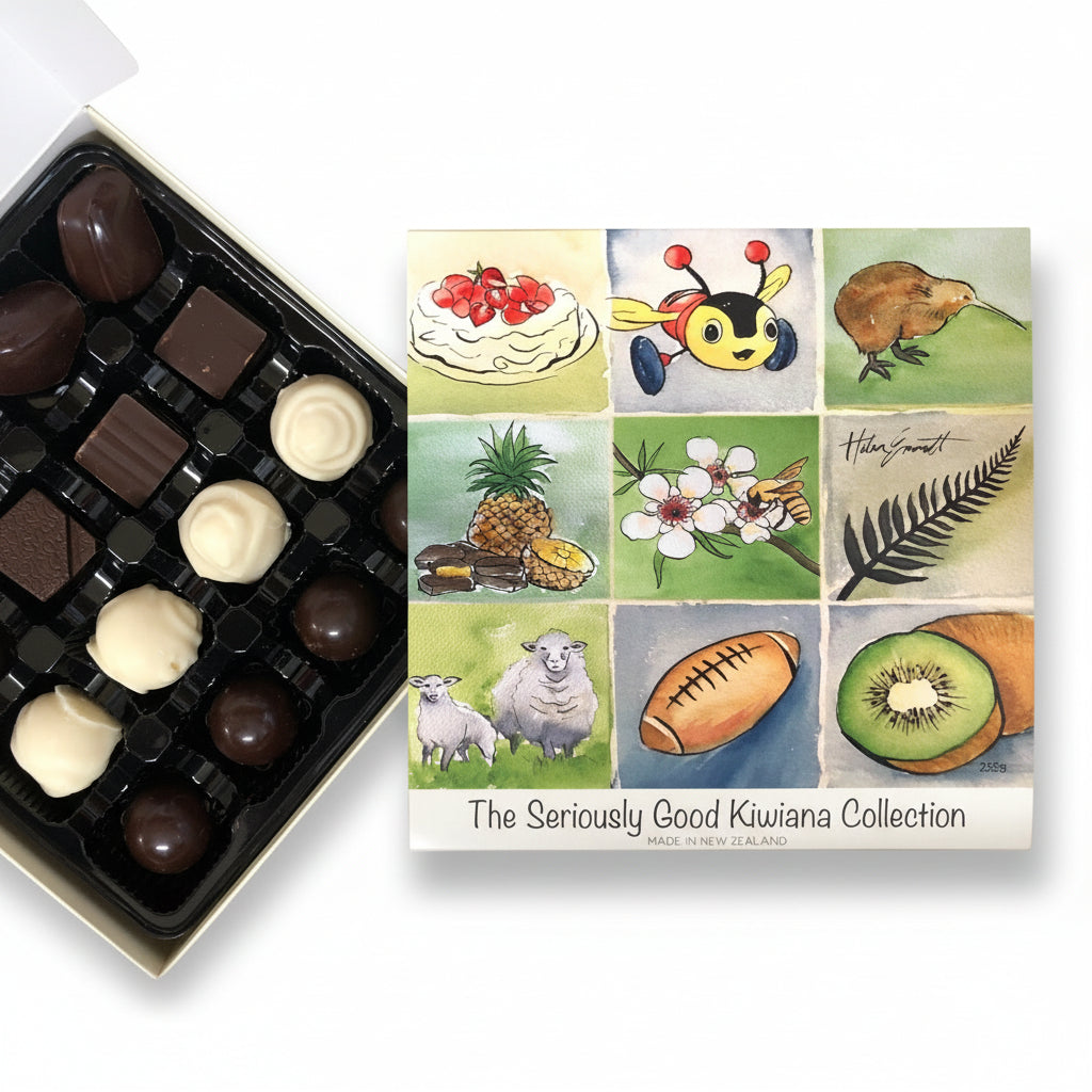 A box of chocolate candies from Kiwiana Watercolour Collection, with artwork by Helen Emmett. The box is open, displaying various chocolates, and a card with the collection's name and artist's signature is visible.