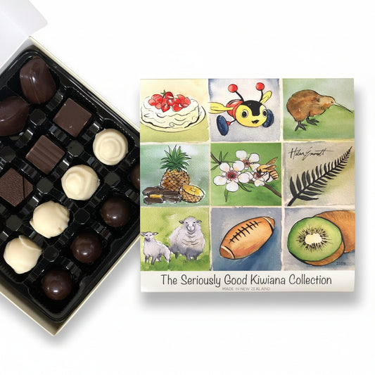 A box of chocolate candies from Kiwiana Watercolour Collection, with artwork by Helen Emmett. The box is open, displaying various chocolates, and a card with the collection's name and artist's signature is visible.
